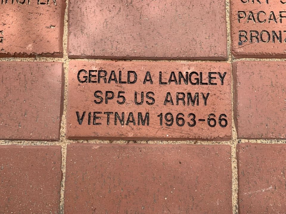 Close view of an engraved memorial brick in the courthouse walk, cut with a name, rank and years of service